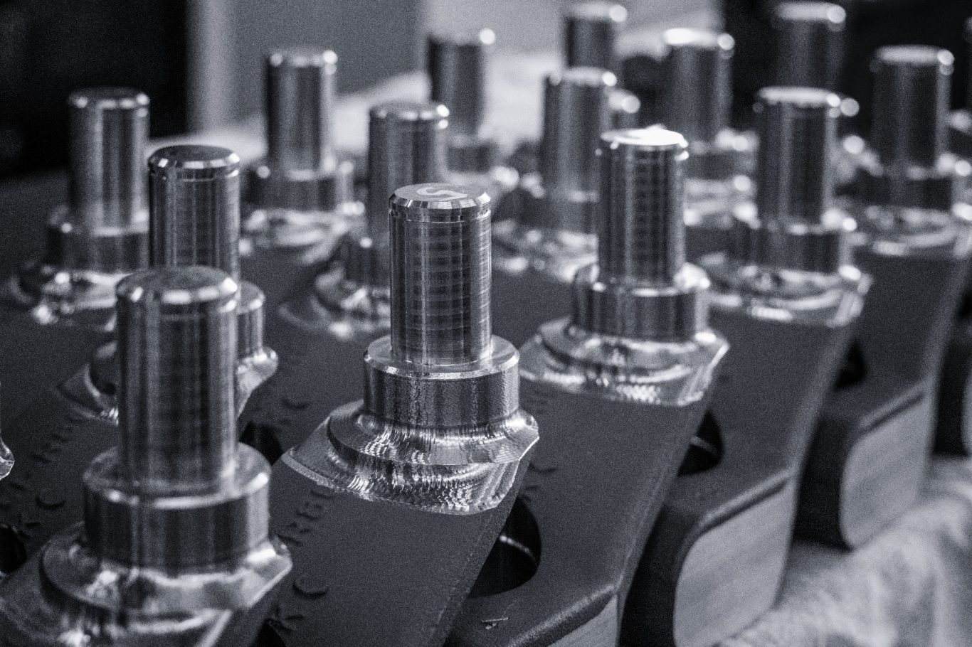 Silberne Schrauben und Bolzen auf einer Werkbank, nah beieinander angeordnet.